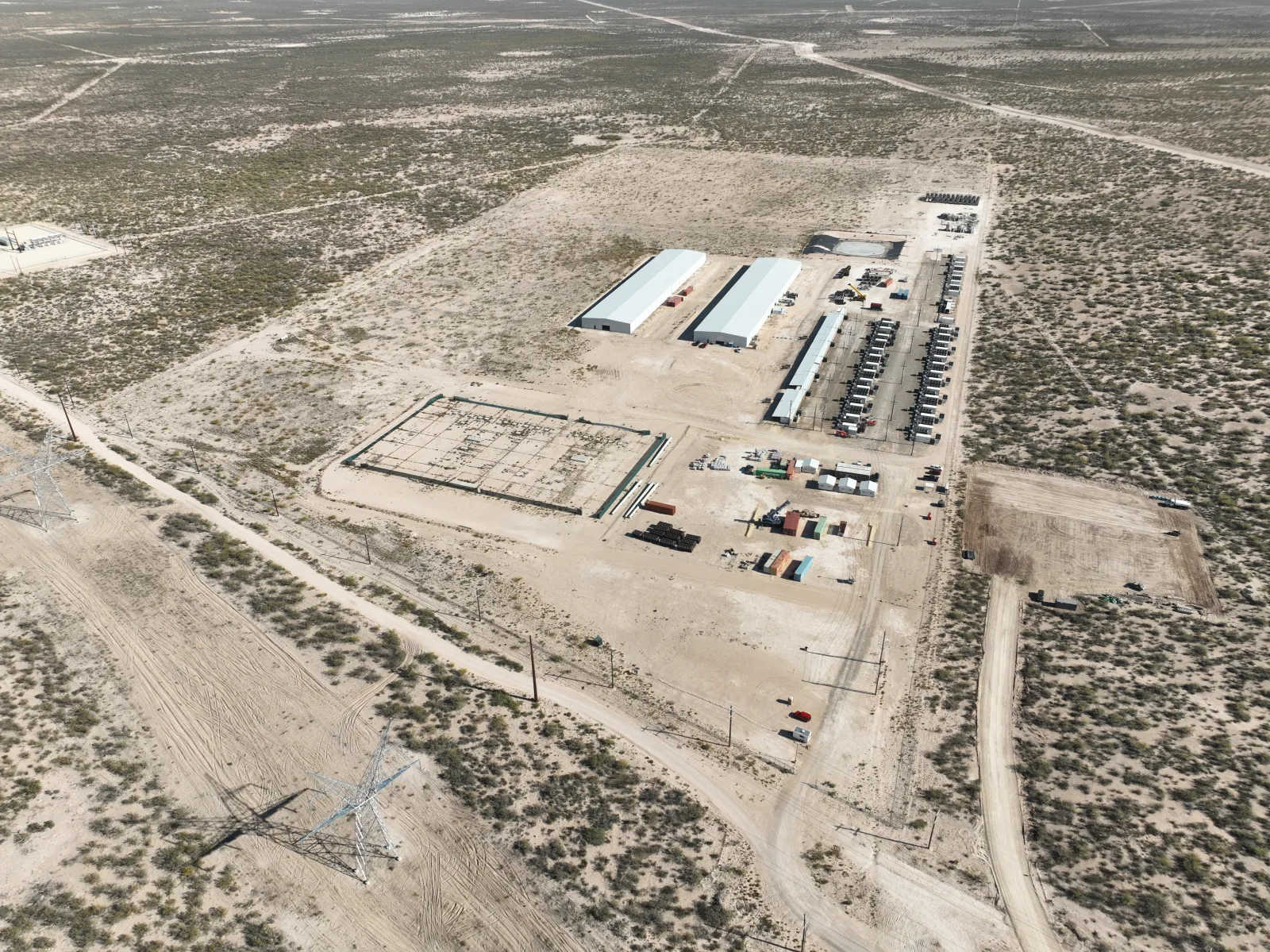 Aerial view of a West Texas digital infrastructure site with buildings, power equipment, and access roads.
